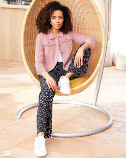 Woman in chair wearing Cotton Traders cord jacket in pink