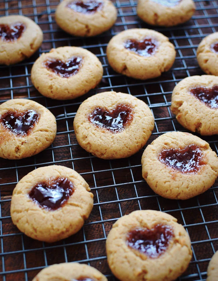 Galletas de mantequilla de maní (cacahuate) y mermelada sobre una rejilla, recién horneadas