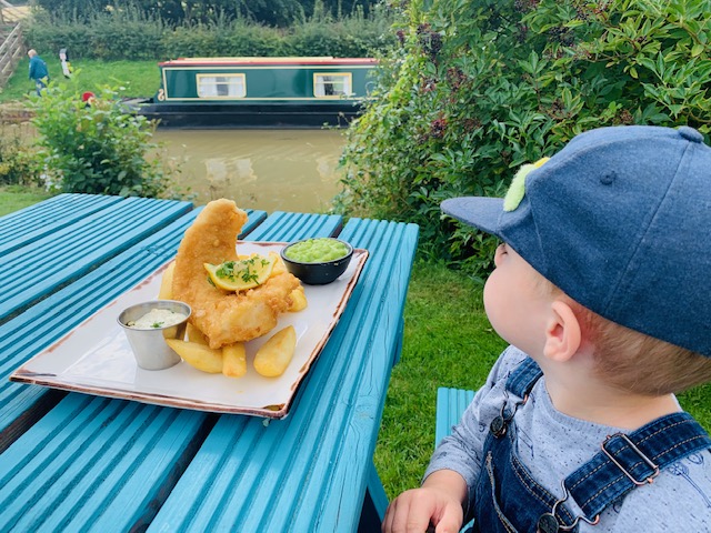 Toddler boy with fish and chips, overlooking the canal