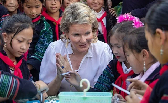 Queen Mathilde wore a printed maxi skirt by Nata, and white silk blouse. Queen Mathilde is making a 3-day working visit to Vietnam