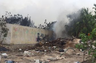 Holbox contaminado: Arden llantas en basurero, gente respira humo negro tóxico