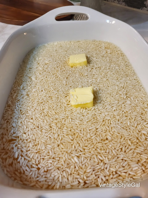 Rice with water and 2 pats of butter in baking dish