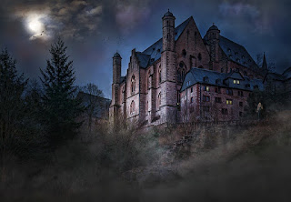 A white tiled and blue roofed manor stands against a clouded nightsky