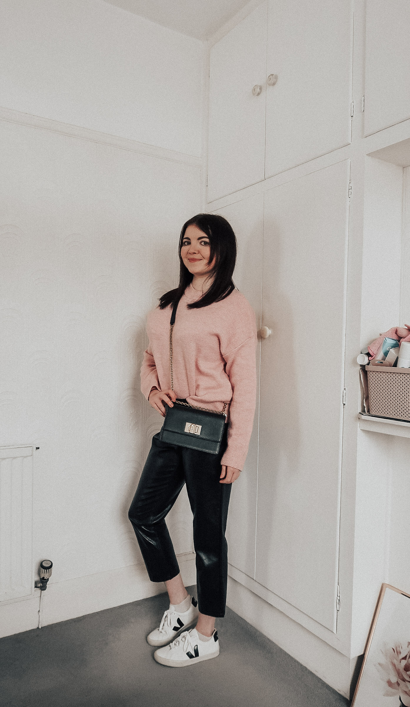 A woman wearing a pink jumper.