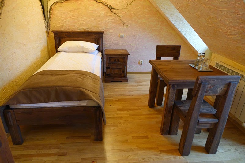 Meble drewniane (łóżko, stół, krzesła).