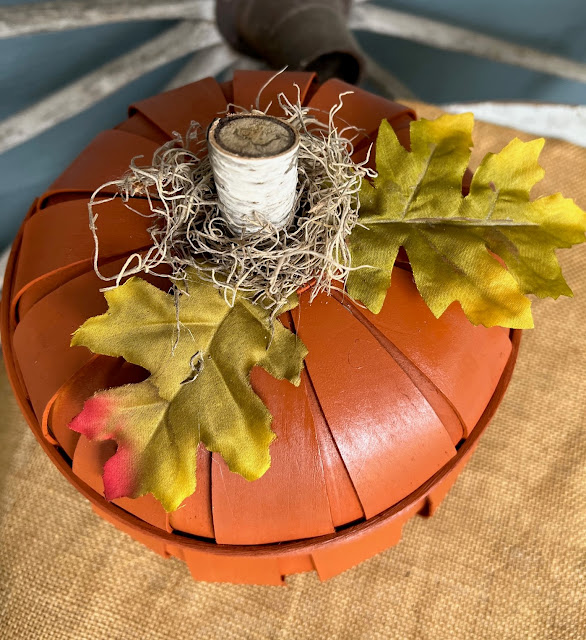 Photo of a basket pumpkin with leaves, Spanish Moss and a birch twig stem.