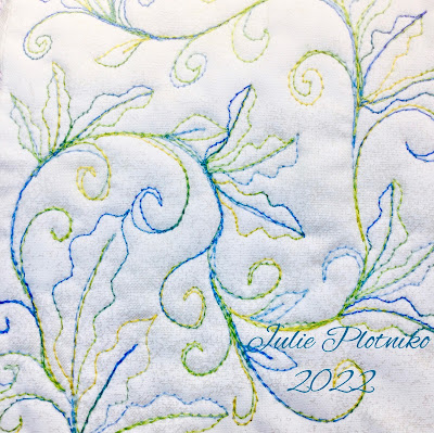A FMQ design stitched with yellow to blue variegated thread