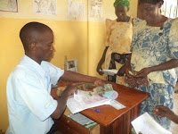 Participants in the PES program receiving their payments for conserving trees. (Credit: Photo courtesy of Chimpanzee Sanctuary and Wildlife Conservation Trust) Click to Enlarge.