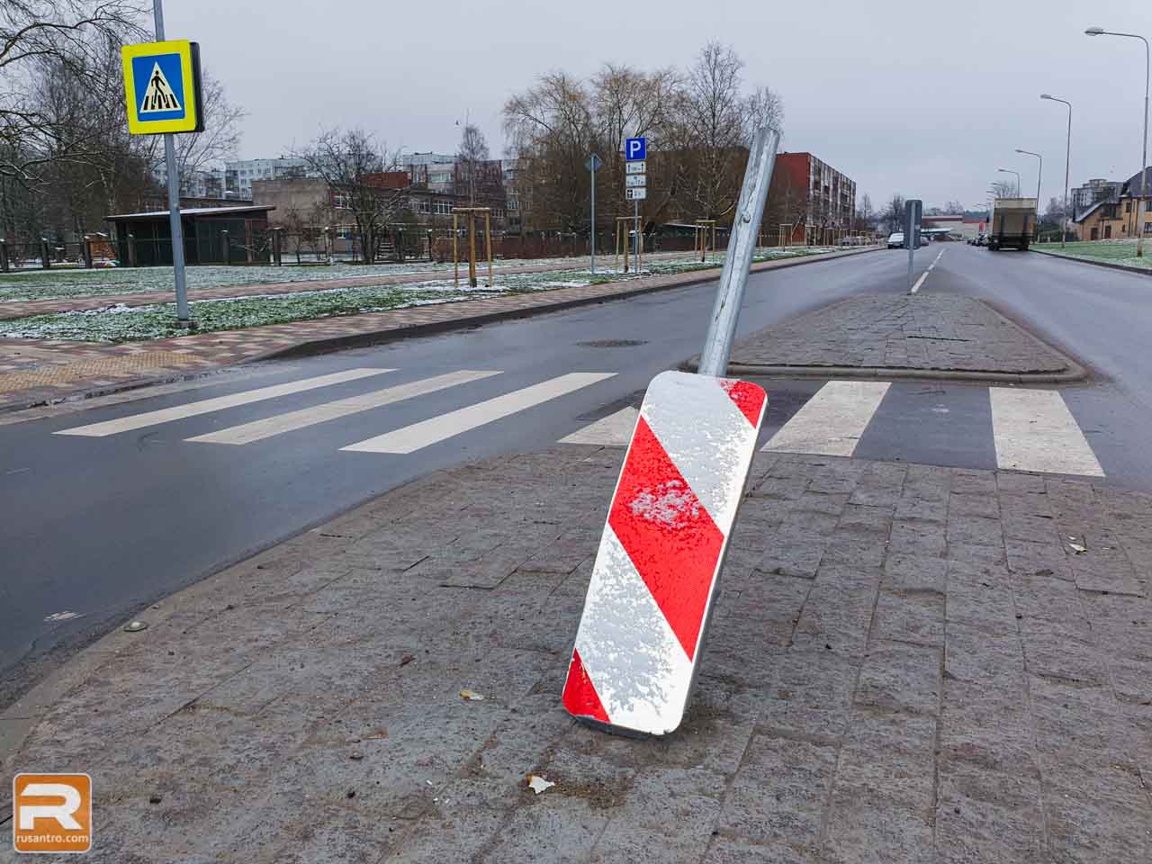 Bojāta ceļu zīme uz gājēju pārejas drošības saliņas