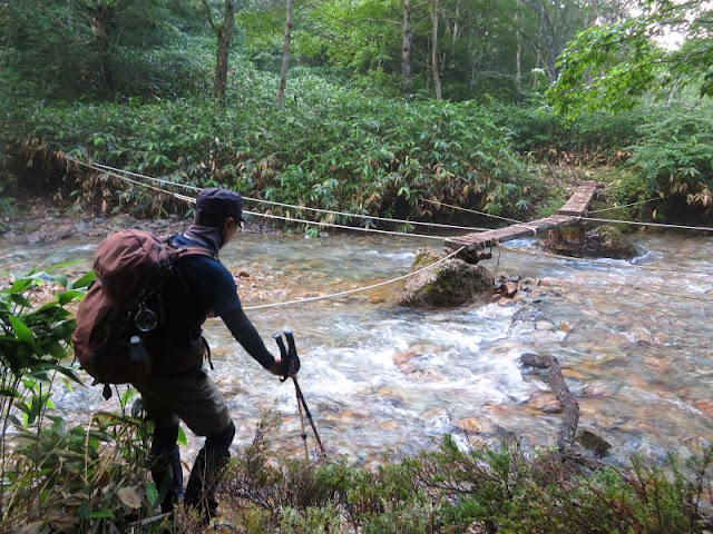 ハンノキ沢を渡る登山者