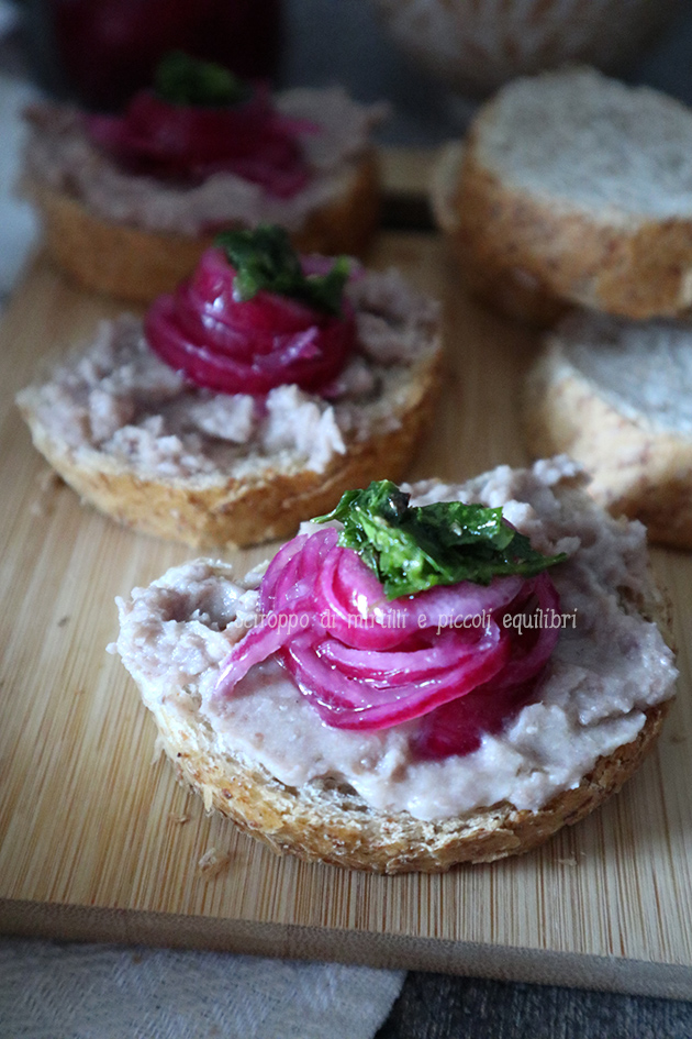 Bruschette di pane integrale con purea di fagioli borlotti, cipolle rosse sott’aceto e chimichurri