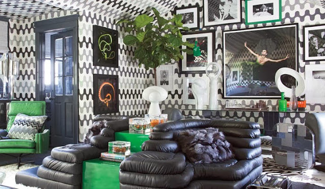 Retro guest apartment with black and green furniture, grey and white graphic print wall covering and lots of art