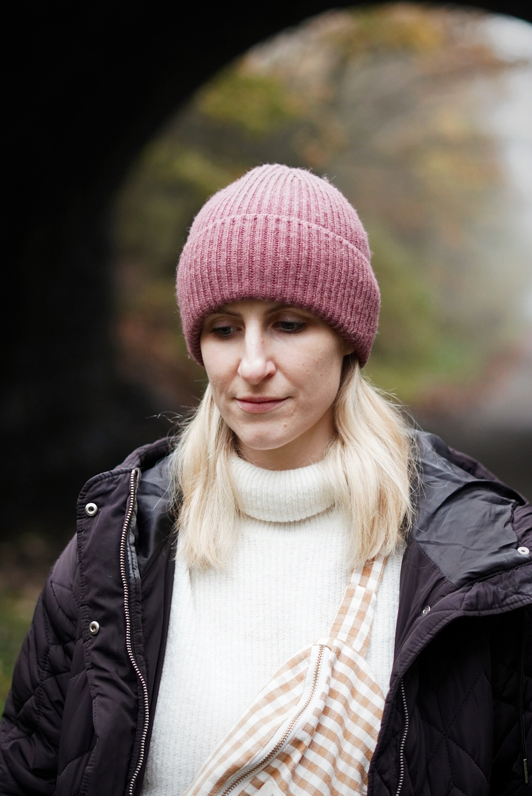 Close up shot of Amy, wearing a pink beanie hat and black puffer coat.