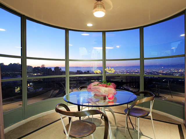 Photo of round glassy table with chairs by the window with Los Angeles view