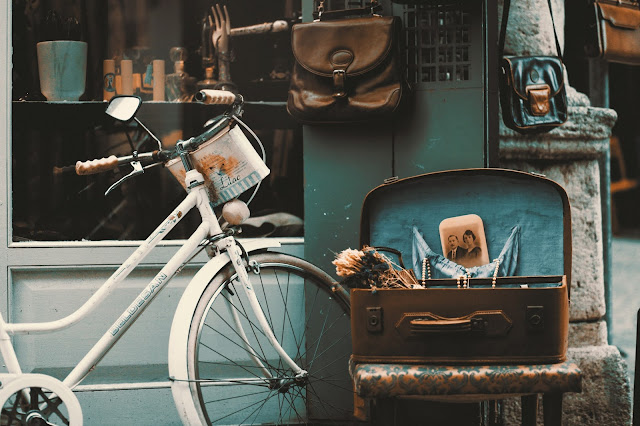 Vintage bike and luggage left outside a store.