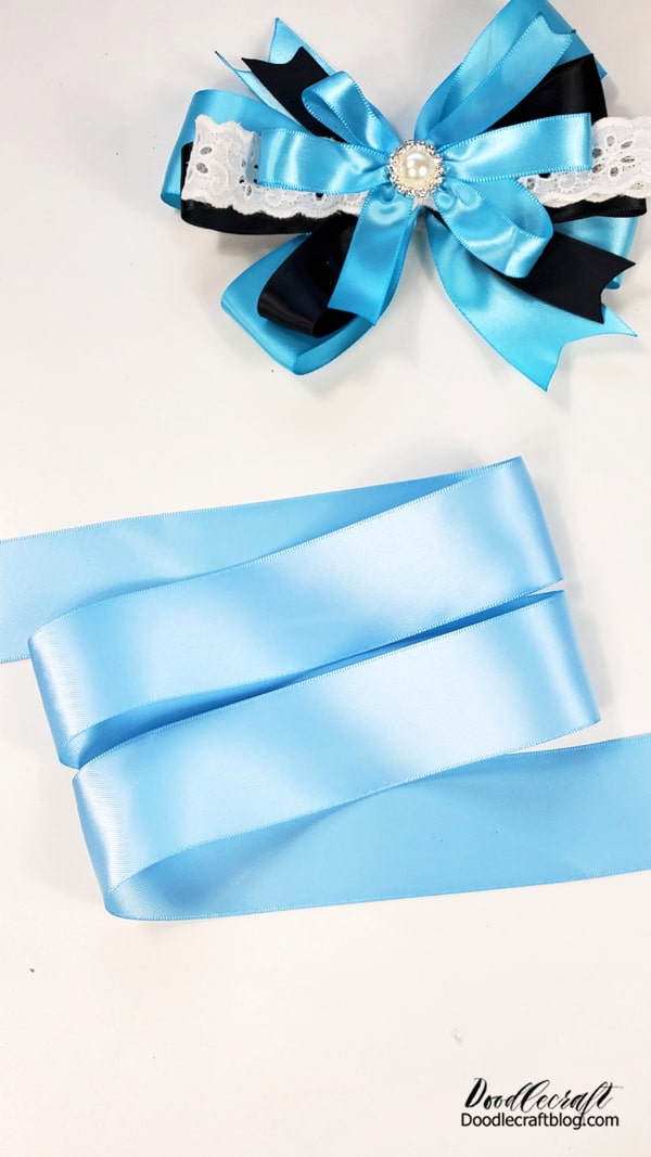 Step 1: Alice in Wonderland Headband Bow  Begin by laying out the widest blue ribbon.   Lay it out in even loops...with 2 loops and one "tail" on each side.