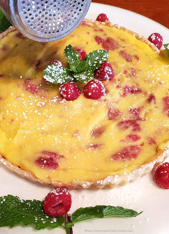 this is a raspberry lemon tart filled into a butter cookie crust with raspberries on top