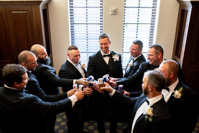 groom toasting with beers with groomsmen