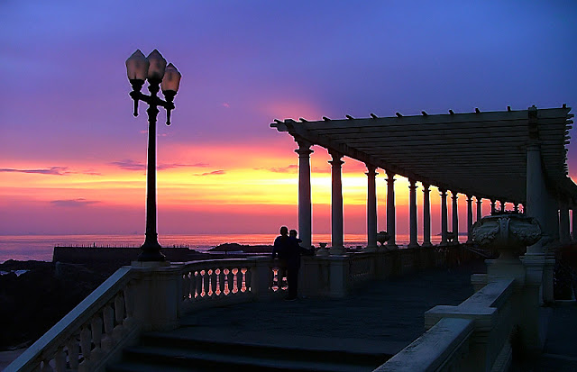 Casal apreciando o pôr do sol na Pérgola do Porto