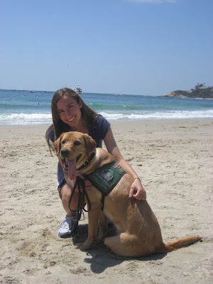 Elizabeth and yellow Lab puppy on the beach