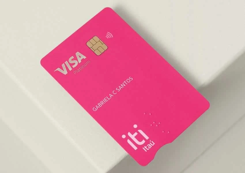 A imagem de fundo claro mostra um cartão na cor rosa do banco digital iti.