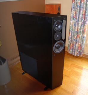 image of black NHT 3.3 speakers inside a room with many wood accents.