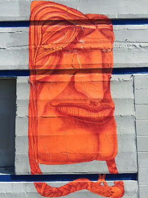 Orange paste-up face on NW Dock Pl Ballard.