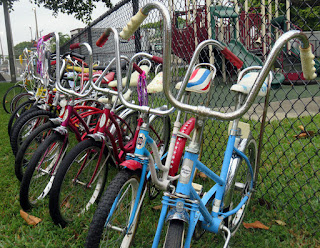 Line of bicycles with tall handlebars.