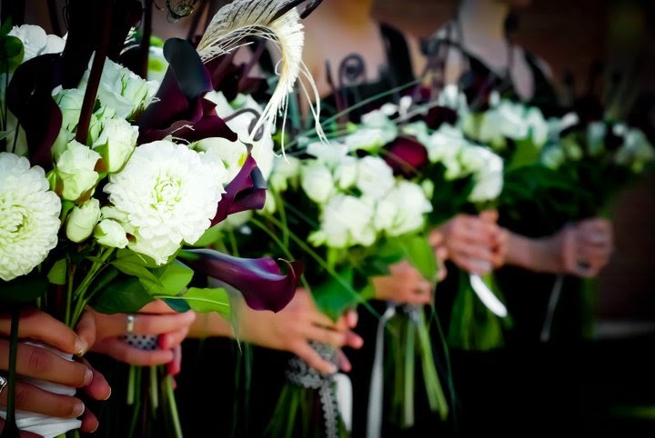 Bridesmaids bouquets included black magic roses white roses and dahlias 