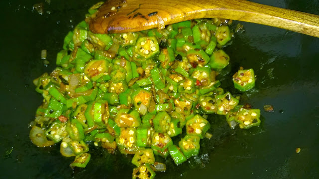 Okra is being fried in a wok