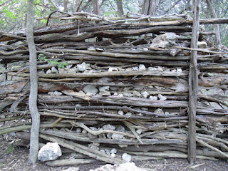 wall made out of sticks and stones, branches and logs