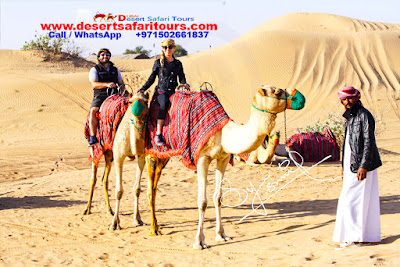 Two people out of three people on the camels for camel trekking at sunrise.