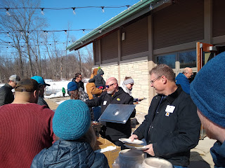 pancake/sausage serving line, woods and snow in background