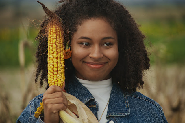 A young woman with a cob of corn (Agbado)