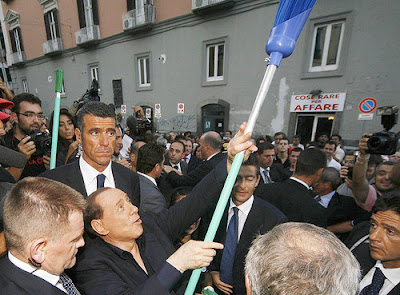 Silvio Berlusconi brandishes a broom in Neaples