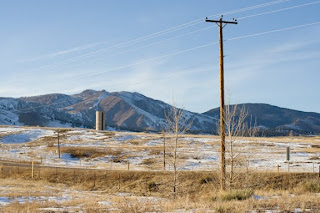 Photo taken from the Left Hand Trail in Boulder of telephone poles, mountains, and a silo