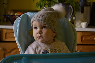 a small girl sitting in the high chair