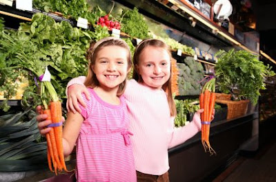 going out NAMC montessori enducation learning independence two girls with carrots