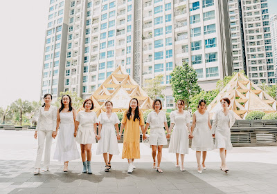 a group of women with a differently dressed person in their middle