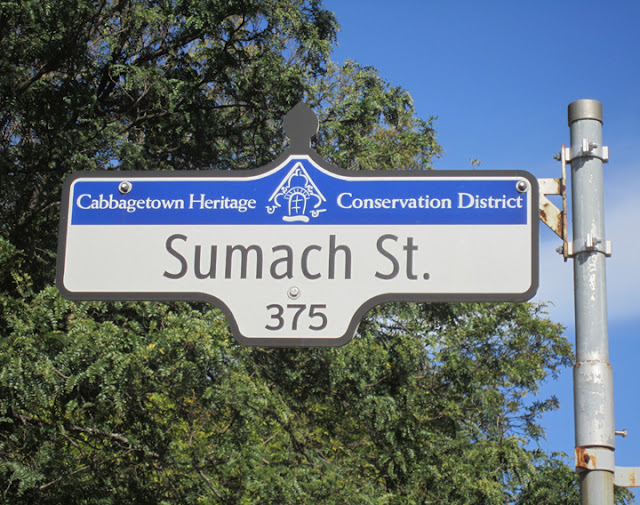 Sumach Street street sign, topped with text for Cabbagetown Heritage Conservation District