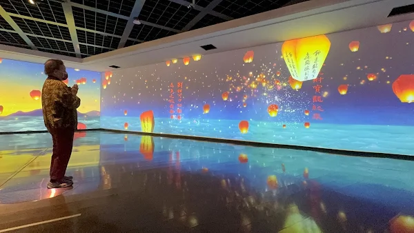 ▲彰化縣立美術館「請眾仙迎神–宮廟藝術展」五樓展場「祈願之地」，以擴增實境「放天燈」Web-AR互動設計，現場可愛阿嬤雙手合十在心中默默祈禱。（記者林明佑攝）