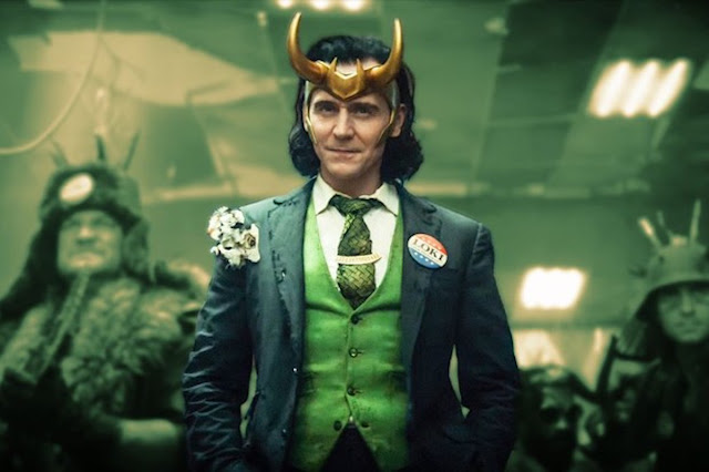 Loki in a green vest presents himself to group