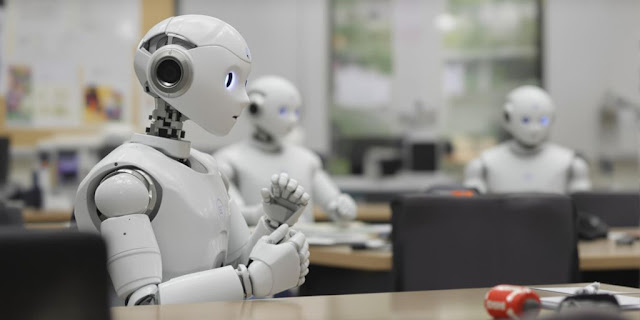 Humanoid robots in a classroom copying from each other.