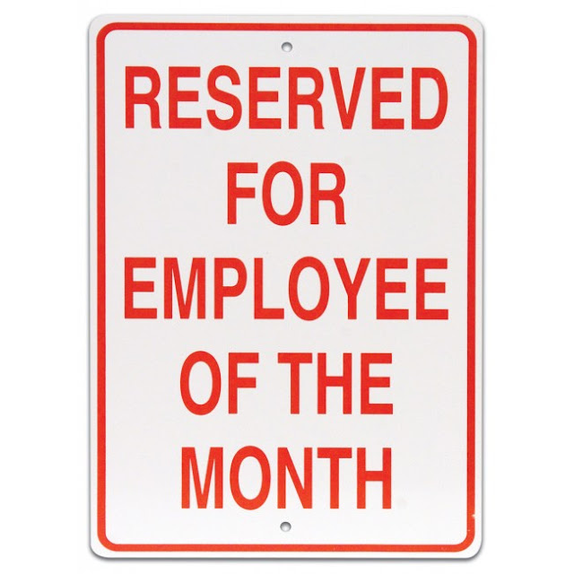 Parking sign that says "Researched for Employee of the Month"