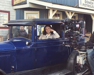 Kayla Wallace sitting inside the classic car while shooting for movie