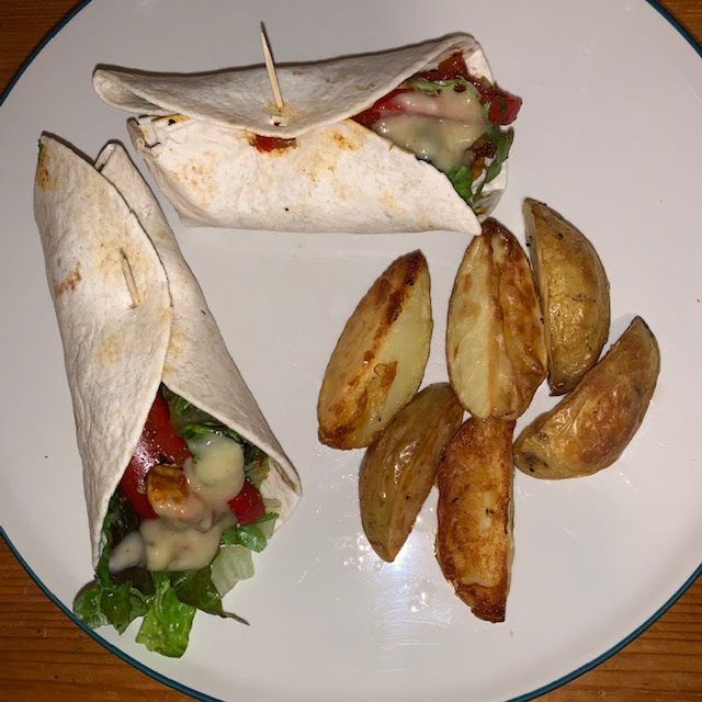 Mango chutney chicken wraps with peppers and lettuce, with potato wedges