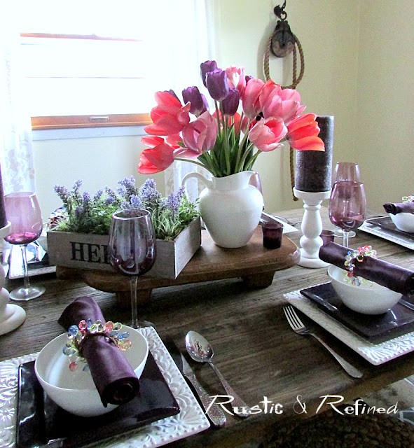 Rustic table setting with tulips and colorful dishes