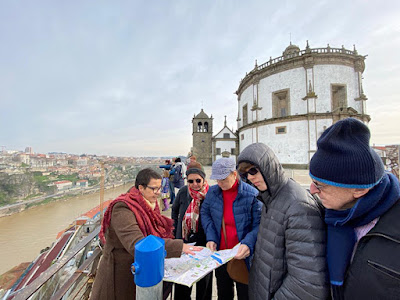 guia brasileira no Porto mostrando o mapa da cidade para um grupo de turistas