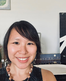 A headshot of the author, with a wide smile and colorful necklace