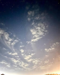 An image of the sky in various hues, from sky-blue to star-speckled violet.